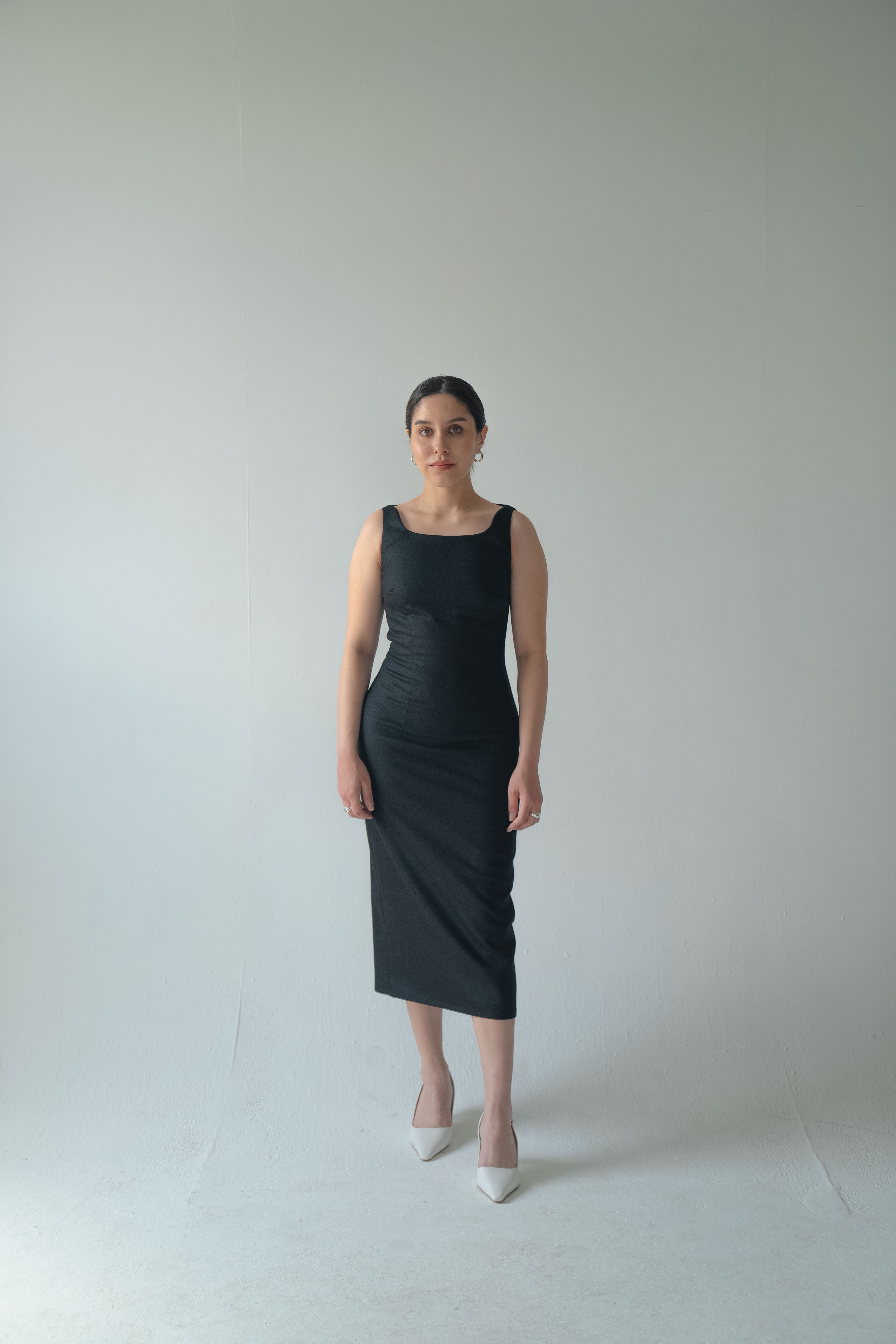 Carol in 90's Midi in Black in front of cyc wall