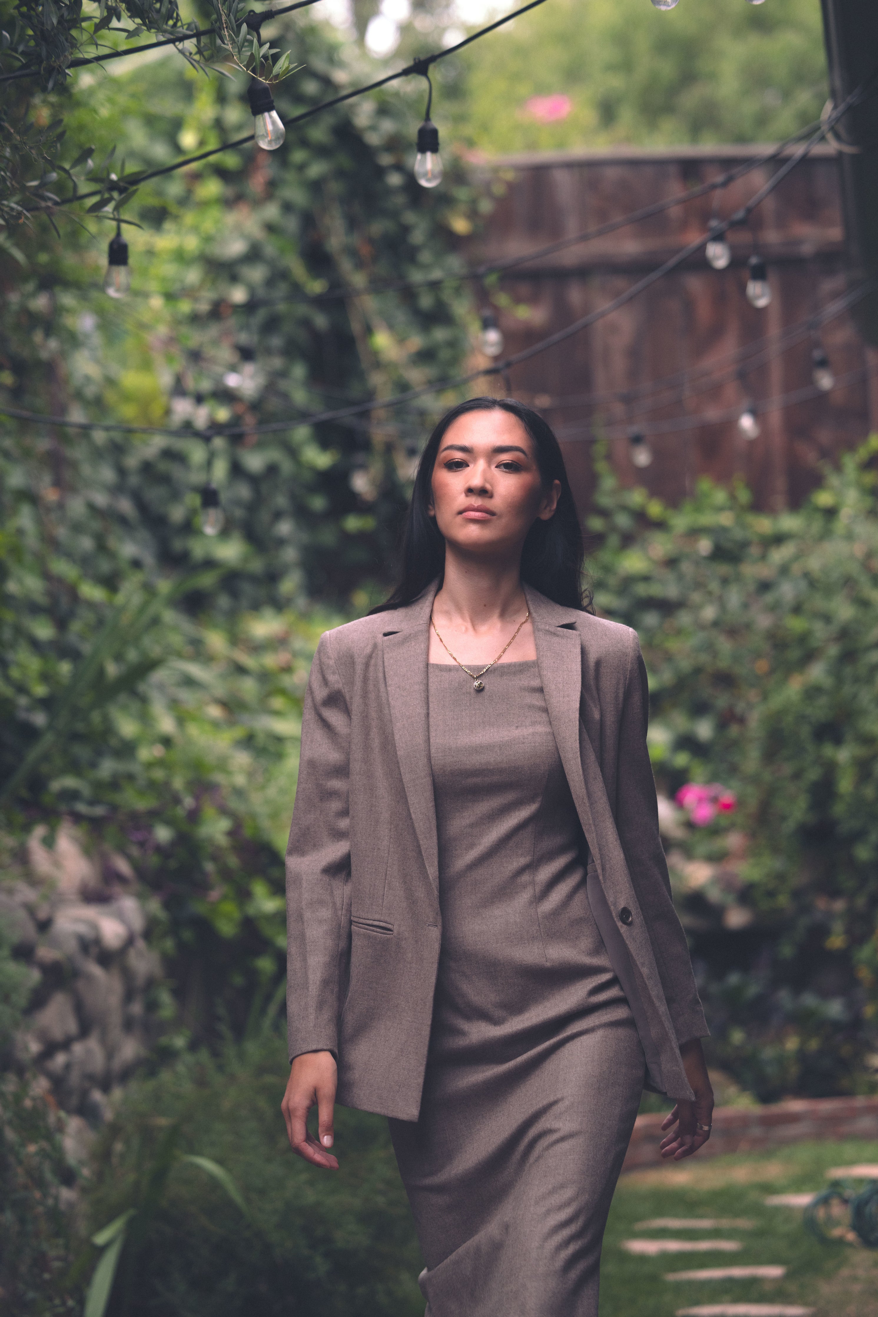 Front view of Alana in garden in 90's Midi and Court Jacket in Coffee